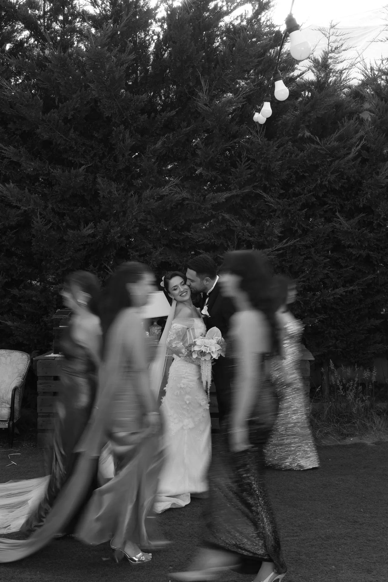 Hareketli davetliler arasında birbirini öpen gelin ve damat